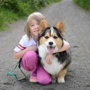 A girl and her corgi on a gravel road at Åsegarden, Harstad