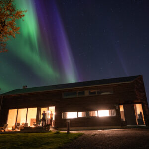 Green and violet aurora over a house at Skagenhaugen, Bø i Vesterålen