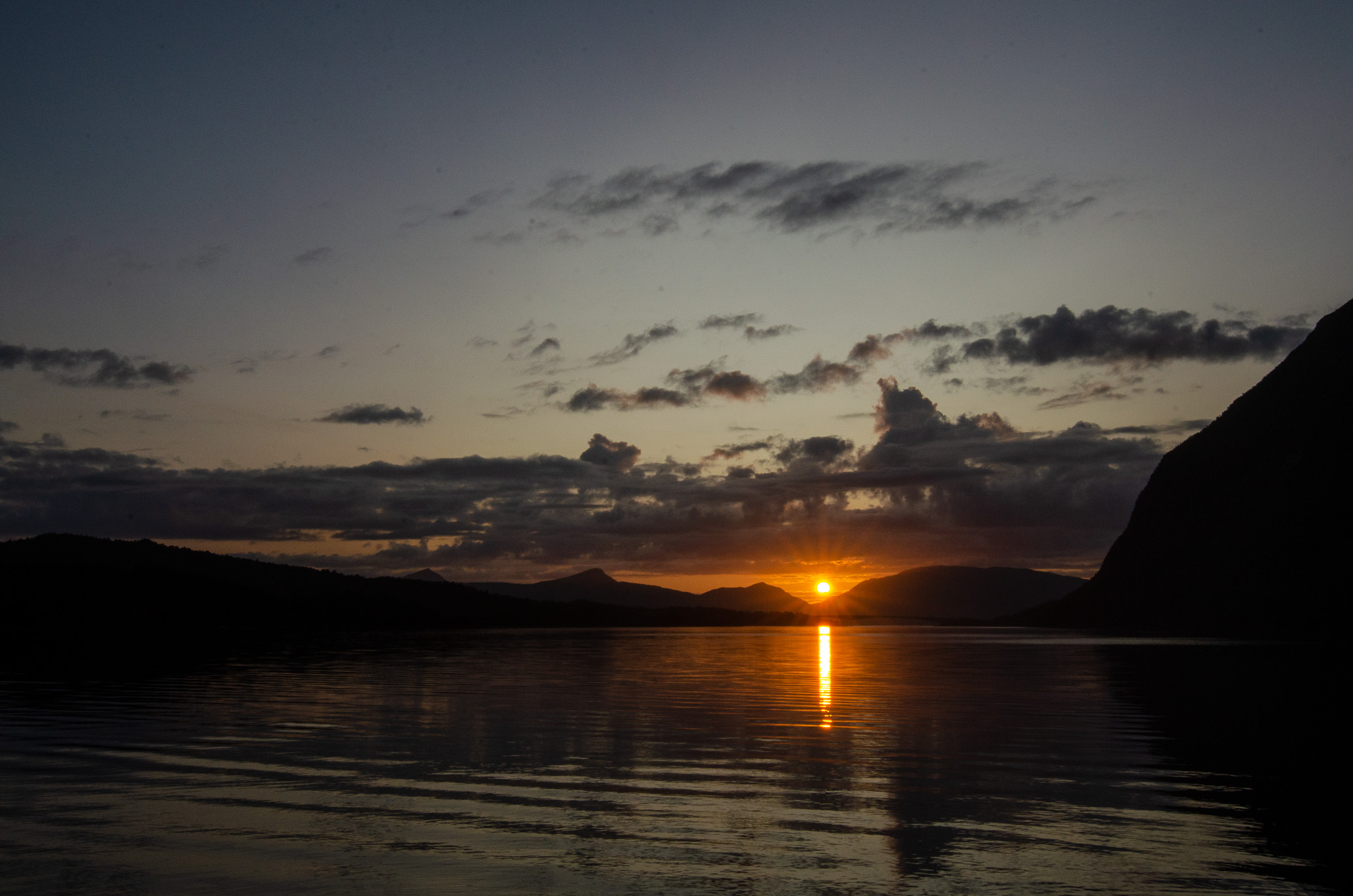Sunset reflected between dark peaks at Djupfjordbotn, Djupfjorden
