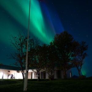 Green aurora above a white house at Skagenhaugen, Bø i Vesterålen