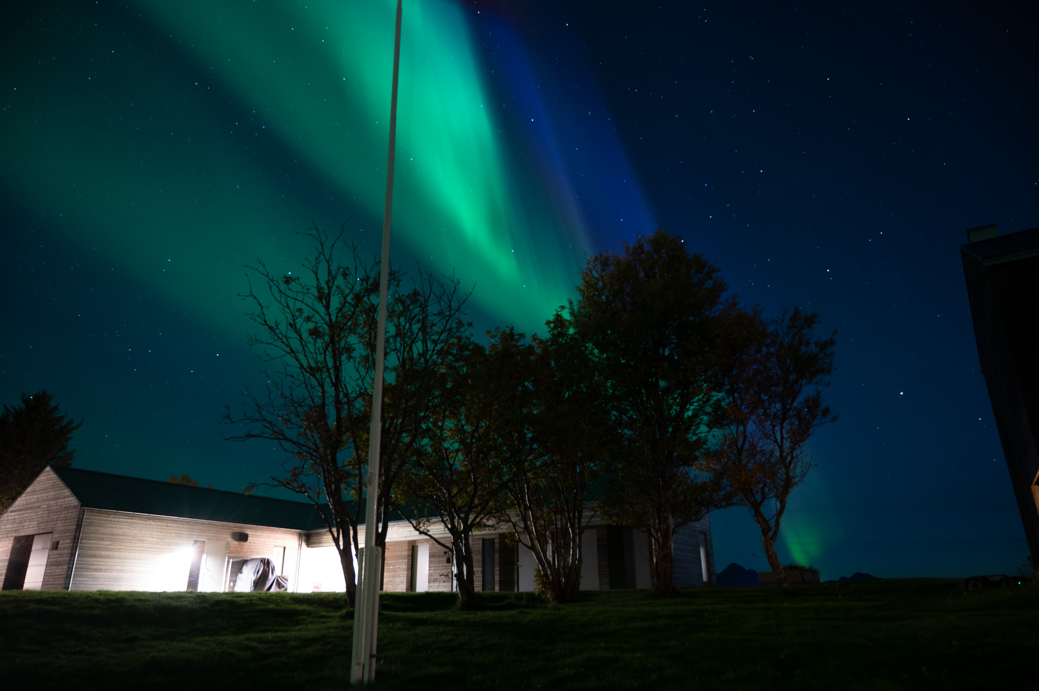 Green aurora above a white house at Skagenhaugen, Bø i Vesterålen