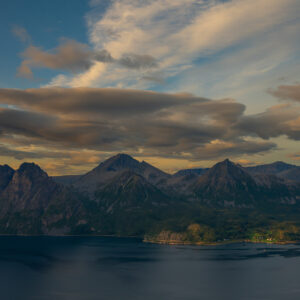 High cirrus clouds drawn across the sky above fjord and mountains
