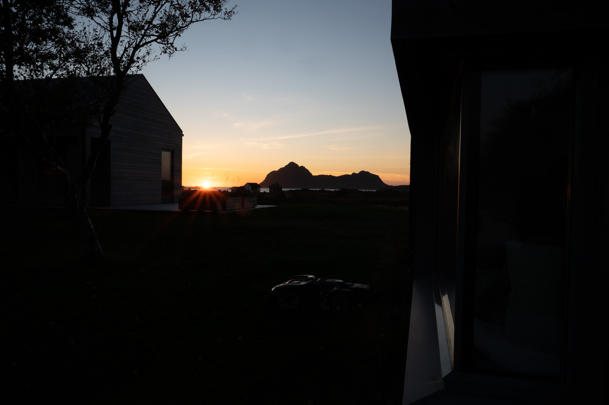 Sunset seen past a dark building edge at Skagenhaugen, Bø i Vesterålen